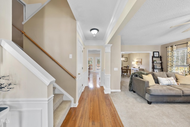 entrance foyer with a healthy amount of sunlight, ornate columns, stairway, and a textured ceiling