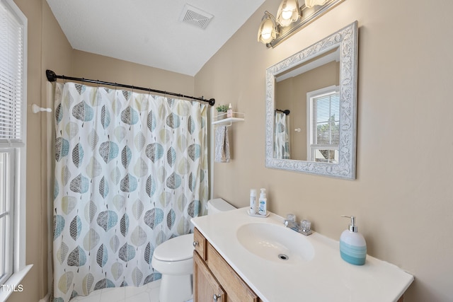 bathroom featuring a shower with curtain, visible vents, toilet, vanity, and tile patterned flooring