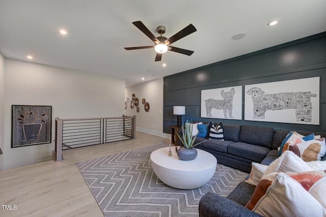 living room with light hardwood / wood-style flooring and ceiling fan