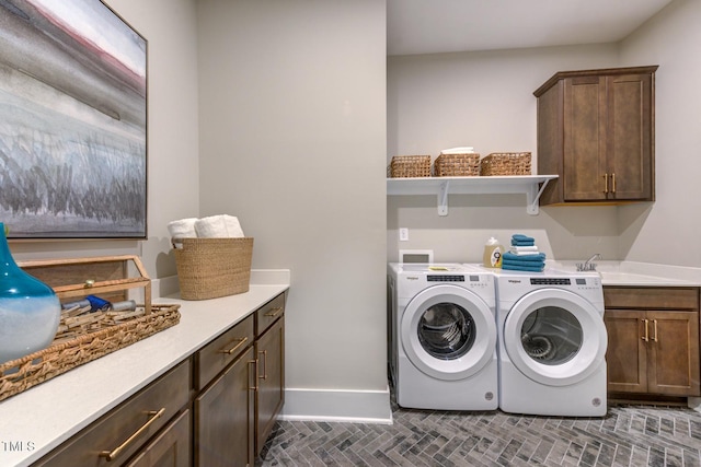 laundry area with independent washer and dryer, cabinets, and sink