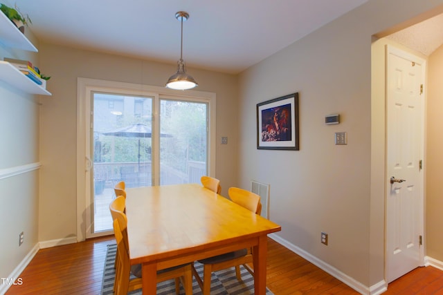 dining room featuring wood finished floors, visible vents, and baseboards