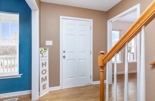 entryway featuring stairs, light wood-style flooring, and baseboards