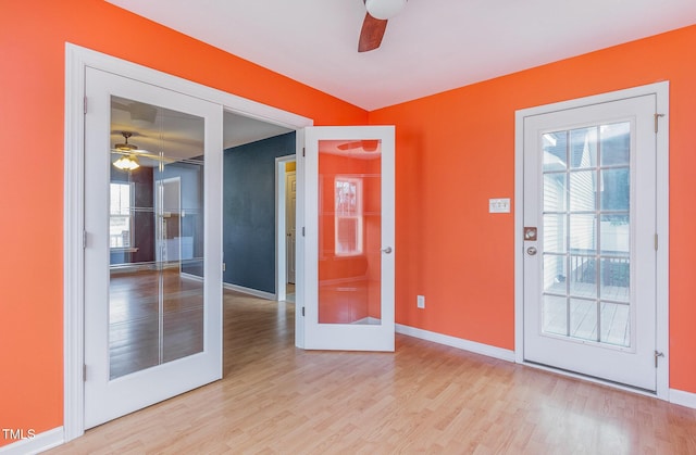 unfurnished room featuring a ceiling fan, baseboards, wood finished floors, and french doors