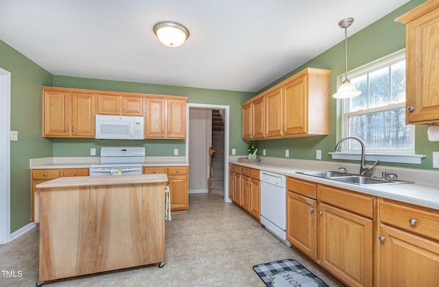 kitchen with white appliances, light countertops, a sink, and decorative light fixtures