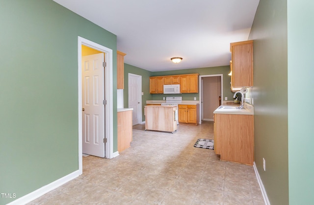 kitchen featuring white appliances, baseboards, light countertops, and a sink