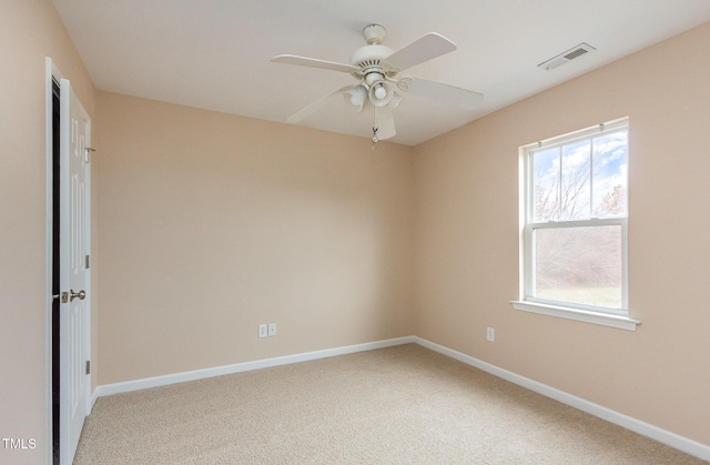 unfurnished room with baseboards, ceiling fan, visible vents, and light colored carpet