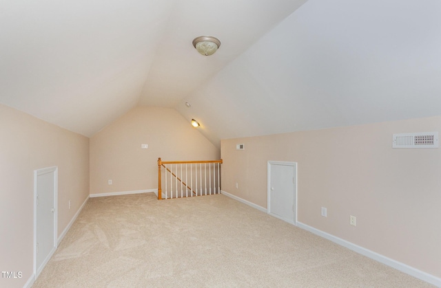 bonus room featuring lofted ceiling, baseboards, visible vents, and light colored carpet