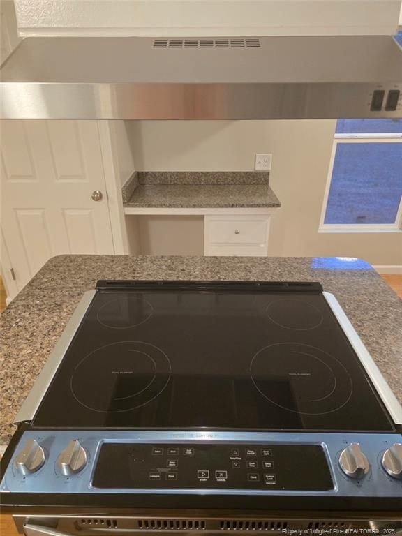 room details with stone counters, white cabinets, and electric stove