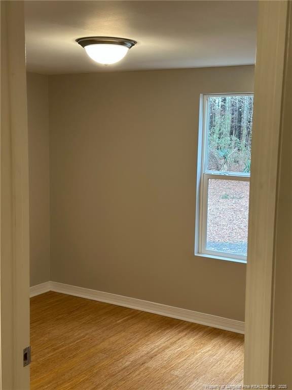 empty room featuring light wood-type flooring and baseboards