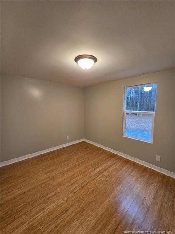 empty room with wood finished floors and baseboards