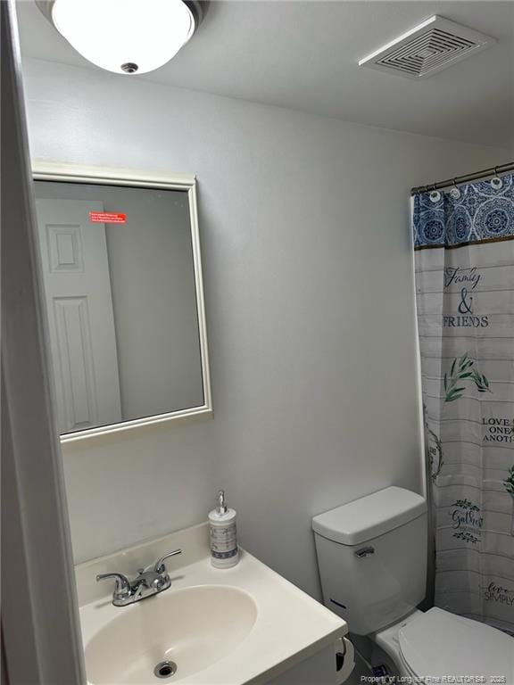 full bathroom featuring toilet, curtained shower, visible vents, and vanity