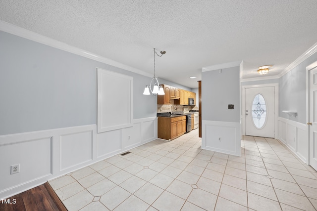 kitchen with light tile patterned floors, a notable chandelier, a textured ceiling, decorative light fixtures, and crown molding