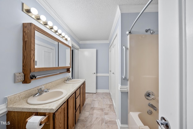 bathroom with a textured ceiling, ornamental molding, vanity, and shower / washtub combination