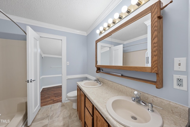 bathroom featuring a textured ceiling, ornamental molding, vanity, and toilet