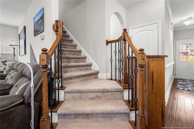 staircase with hardwood / wood-style flooring and ornamental molding