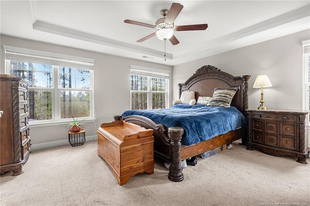 carpeted bedroom featuring crown molding, ceiling fan, and a tray ceiling