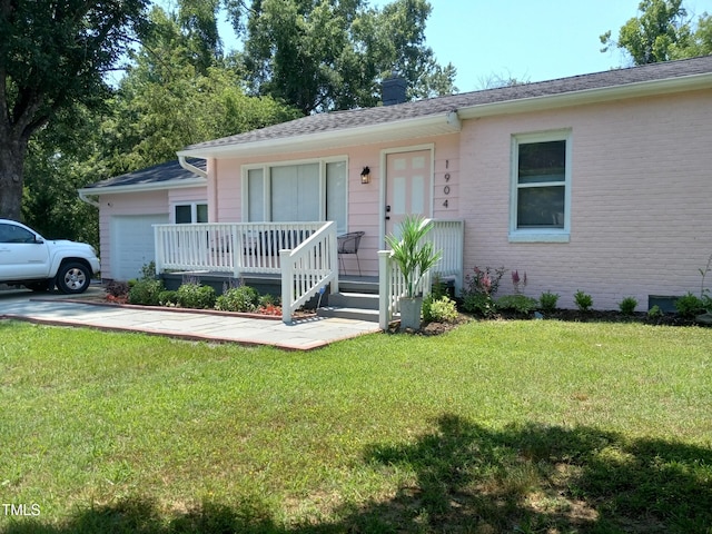 ranch-style house featuring a garage, a front yard, and covered porch