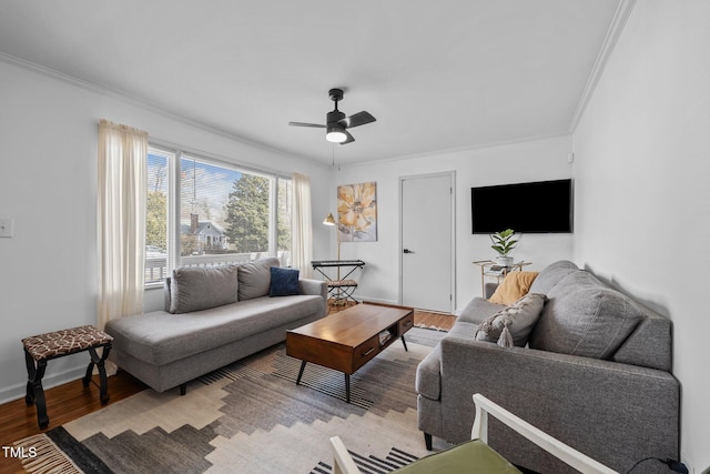 living room with light wood-style floors, ceiling fan, baseboards, and crown molding