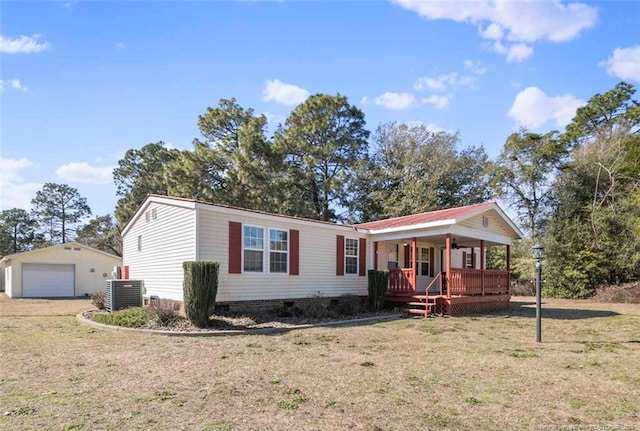 view of front facade with an outbuilding, a garage, a front yard, and a porch