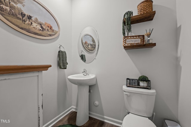 bathroom with hardwood / wood-style flooring, toilet, and sink