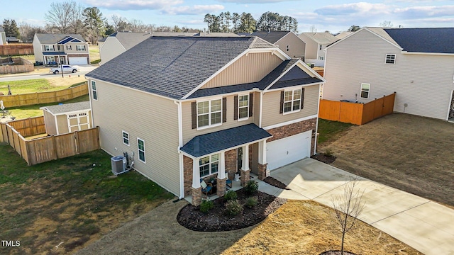 view of front of property featuring central AC unit, a garage, and a front lawn