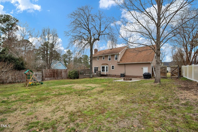 view of yard featuring a gate, central AC, a fenced backyard, an outdoor fire pit, and a wooden deck