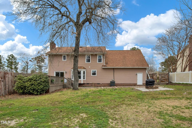 rear view of property with a yard, central AC unit, a fenced backyard, and a chimney