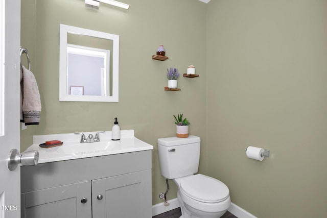 bathroom featuring vanity, toilet, and baseboards