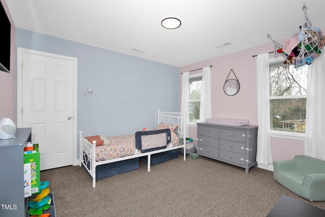 carpeted bedroom featuring visible vents