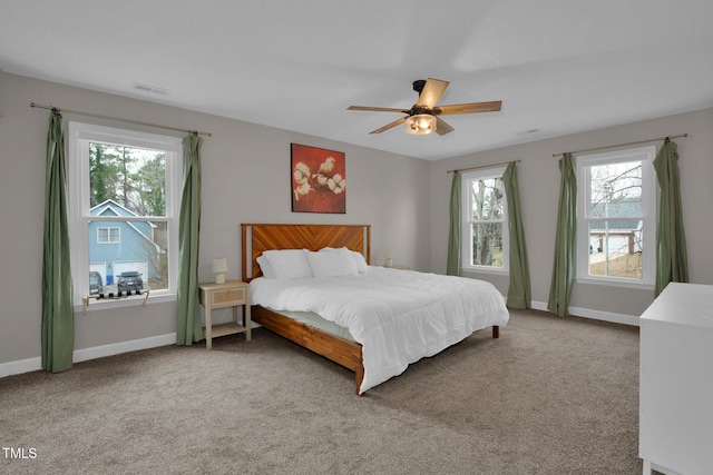 carpeted bedroom with visible vents, a ceiling fan, and baseboards