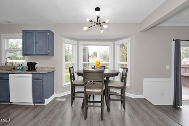 dining area with a notable chandelier, a healthy amount of sunlight, and dark wood-style flooring