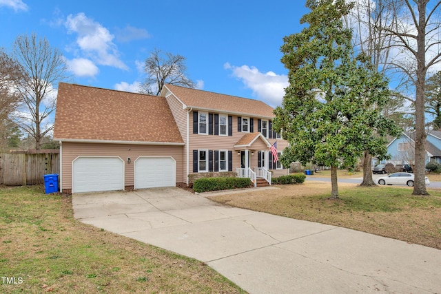 colonial home with fence, roof with shingles, a front yard, a garage, and driveway