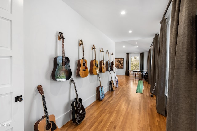 corridor featuring light wood-type flooring, baseboards, and recessed lighting