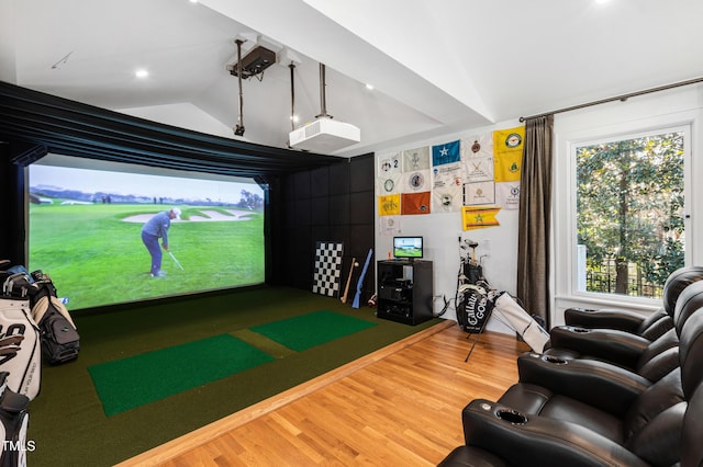 game room featuring lofted ceiling, golf simulator, and wood finished floors