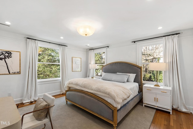 bedroom featuring multiple windows, baseboards, wood finished floors, and recessed lighting