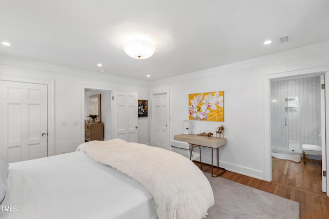 bedroom with recessed lighting, visible vents, connected bathroom, wood finished floors, and baseboards