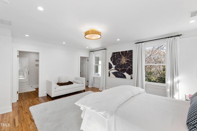 bedroom with light wood-style floors, recessed lighting, visible vents, and connected bathroom