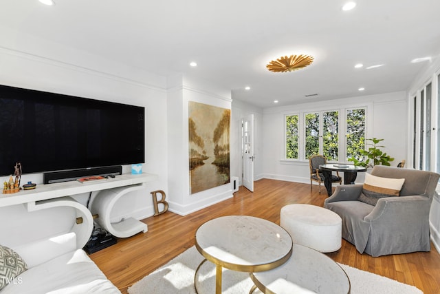 living area with recessed lighting, baseboards, and wood finished floors