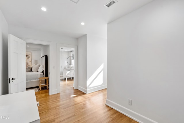 interior space featuring light wood-type flooring, baseboards, visible vents, and recessed lighting