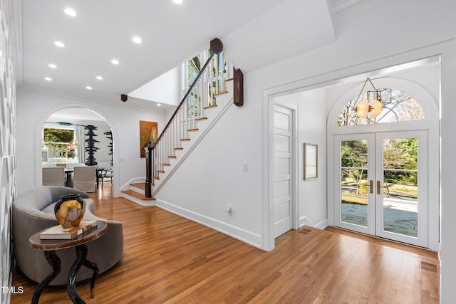 foyer entrance featuring arched walkways, visible vents, french doors, stairway, and plenty of natural light