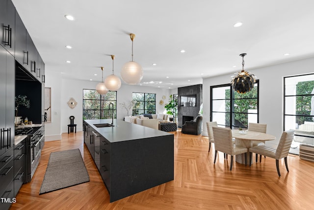 kitchen featuring modern cabinets, dark cabinetry, a sink, and recessed lighting