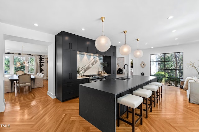 kitchen with backsplash, plenty of natural light, a sink, and dark cabinets