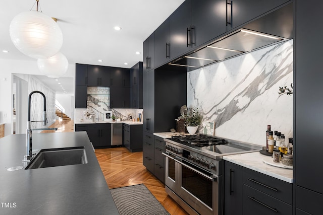 kitchen featuring range with two ovens, a sink, backsplash, modern cabinets, and pendant lighting