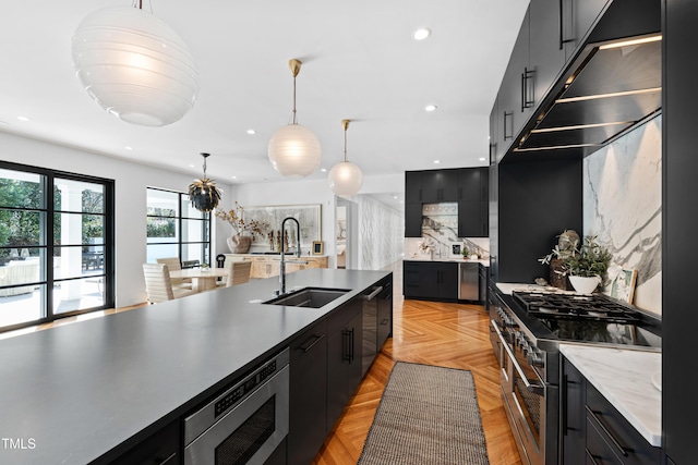 kitchen with appliances with stainless steel finishes, recessed lighting, a sink, and dark cabinets