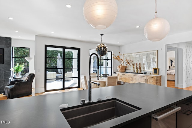 kitchen with recessed lighting, open floor plan, a sink, light wood-type flooring, and dishwasher