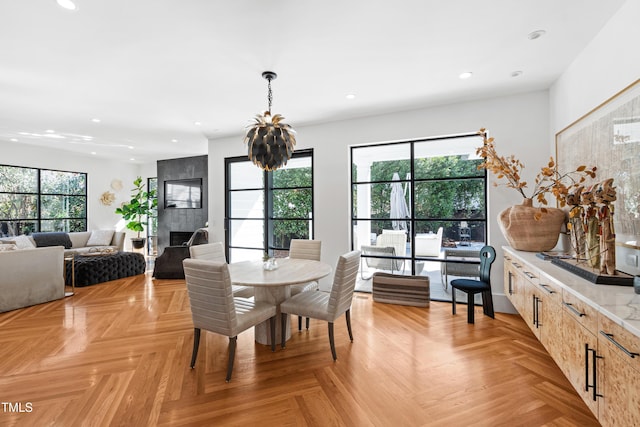 dining space with a chandelier, a fireplace, and recessed lighting