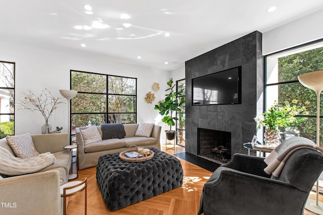 living area with a wealth of natural light, a tiled fireplace, and recessed lighting