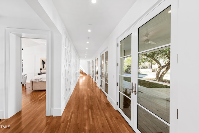 hallway with recessed lighting, french doors, and wood finished floors