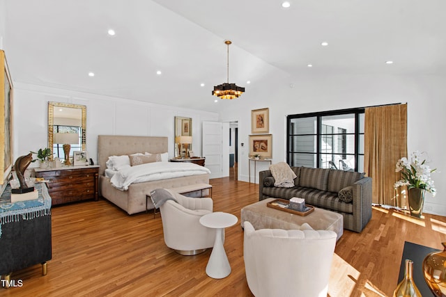 bedroom with lofted ceiling, recessed lighting, light wood-style flooring, and an inviting chandelier