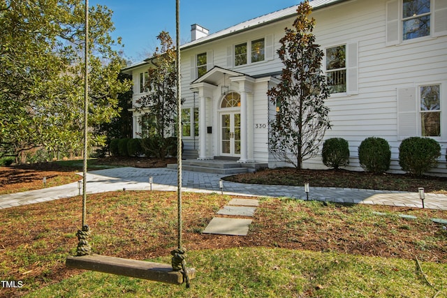 view of front of home with french doors and a chimney